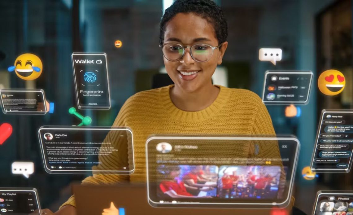 A smiling young Black woman wearing glasses interacting with a futuristic digital interface, surrounded by numerous floating holographic screens displaying social media posts, chats, a digital wallet with fingerprint authentication, and various emojis, representing immersive technology.
